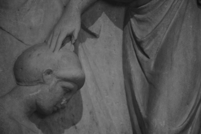 Ancient Greece, detail of statue, hand touching a head, Arceological museum of Athens.